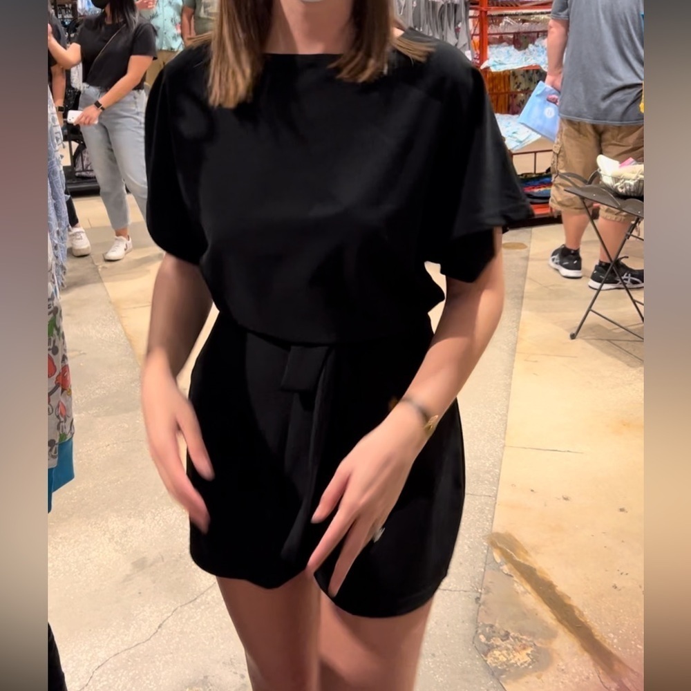 Flattering black romper, slick material with waist tie and button at back neck